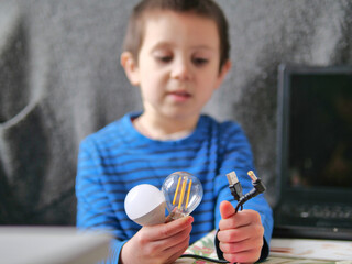 Boy Holding Lightbulbs and USB Power Cable for Technology Science Project - transition to LED and smart power. connecting ideas, Visuals for coding, electronics, or physics modules for kids
