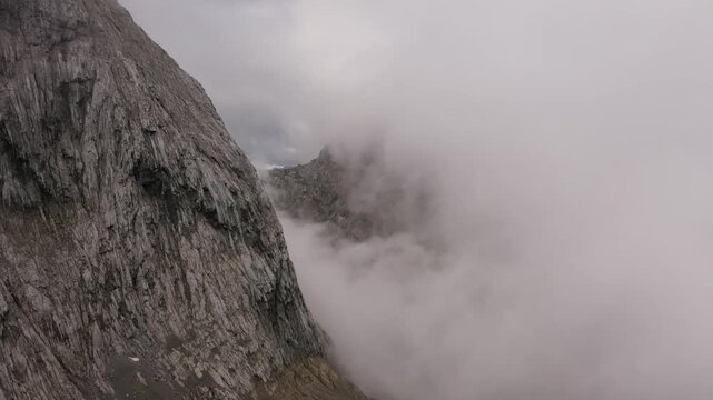 Aerial View of Vertical Roc Cliff Face Disappearing ito Dense Fog