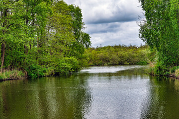 2025-05-06 A LOVELY CANAL WITH A NICE REFLECTION GREENERY AND A CLOUDY SKY ON THE BANKS IN NORWICH ENGLAND