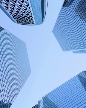 low angle view of modern glass skyscrapers against blue sky