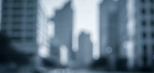Blurred city skyline with tall modern buildings forming an abstract urban background, suitable for business layouts, corporate branding, websites, and advertising designs.