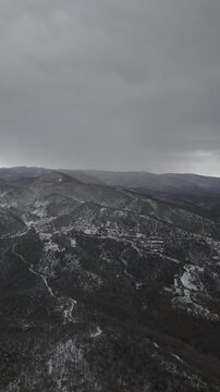A serene winter landscape of the snow-covered mountains in Termal, Yalova, featuring white snowy peaks and dense pine forests. The peaceful natural scenery captures the beauty of the Turkish winter, m