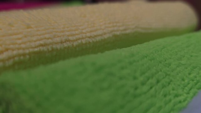 Macro close-up of soft microfiber fabric textures in various colors showing fiber details and stitching