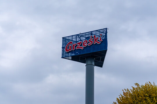 Grześki advertising pylon with brand logo mounted on tall pole near road in Poland daytime