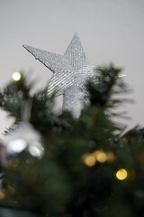 Close-Up of Silver Glitter Star on Top of Christmas Tree