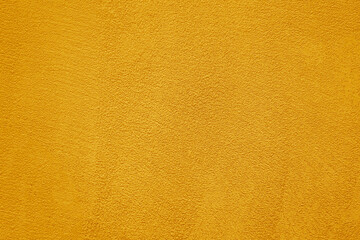 Background of natural yellow gold golden stucco in plaster cement texture lined pattern or stone in colors aged Textured illuminated wall fence surface blend of warm sunny tones backdrop.