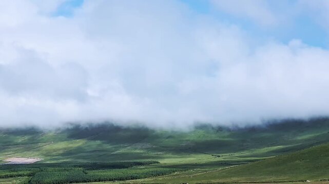Green Irish pastures with moving clouds next to Kerry Cliffs, Portmagee, Ring of Kerry, Ireland. timelaps
