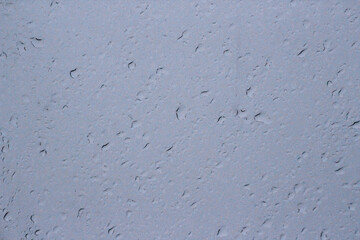 Transparent plastic texture with water drops. Transparent white plastic background. Wet transparent polyethylene film with droplets of water after rain. Water drops close-up.