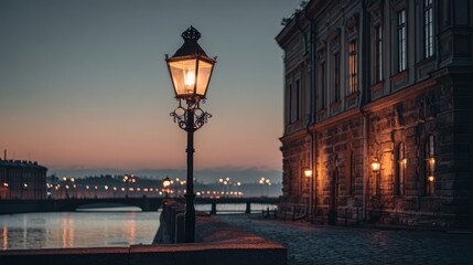 Twilight cityscape with ornate lamppost illuminating cobbled street, reflecting light onto river. Historic building adds texture, horizon blurred by distance
