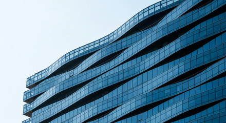 Blue glass facade of modern building, wavy lines creating dynamic design, showcasing architectural detail and contemporary style, suitable for corporate background