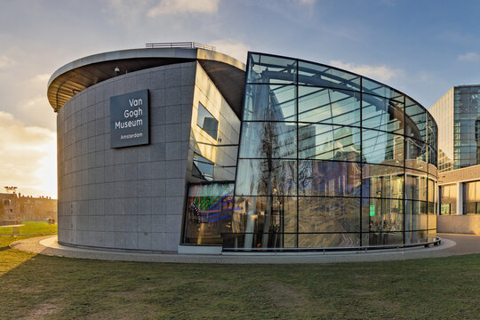 Modern glass entrance hall of the Van Gogh Museum during sunset. Contemporary architecture at Museumplein with reflections and light. Amsterdam Netherlands, 28 december 2025