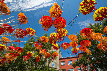 Bright multi-colored umbrellas and flowers against the blue sky