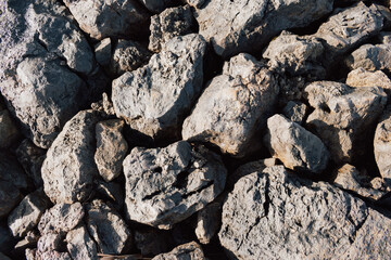 Pile of sharp broken stones and rubble close-up forming an uneven construction industry background