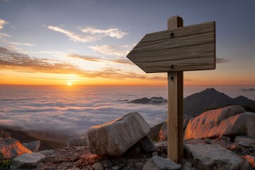 Wooden signpost above clouds at mountain sunrise