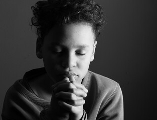 little boy praying to God with hands together with people stock image stock photo 