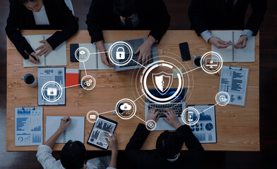 A group of business professionals engaged in a collaborative meeting focused on data security strategies, utilizing digital tools and visual analytics to enhance cybersecurity. Trope