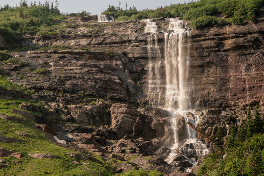 Morning Eagle Falls Cashes Down On Large Rocks In Glacier