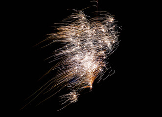 Spectacular show of glittering fireworks bursting into radiant golden sparks and embers