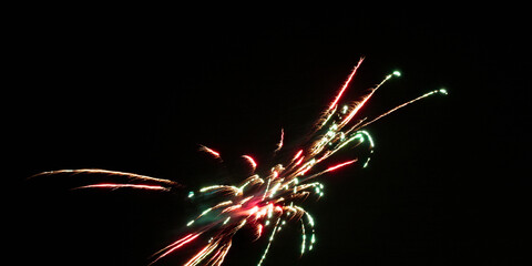 Multicolored pyrotechnics streak across dark sky during enthusiastic backyard party