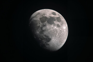 Partially lit moon with craters lunar surface gray