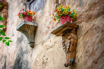 Rustic Wall Shelves with Flower Pots on Old European Facade