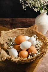 Easter eggs background. White eggs in rustic bowl and gypsophila flowers. Spring holiday