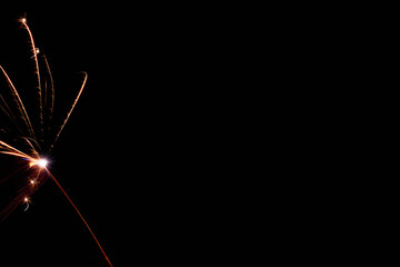 Fragile bursts of tangerine radiance cut across night sky creating calm celebrations