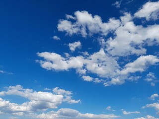 Beautiful deep blue sky with white fluffy clouds on a sunny day