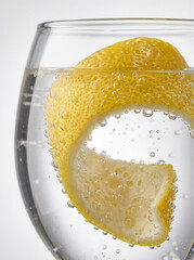 Lemon Peel Swirling in Sparkling Water with Effervescent Bubbles