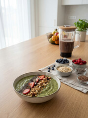 Vibrant Green Smoothie Bowl with Fresh Berries and Granola on a Modern Kitchen Counter