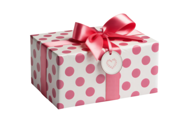 Wrapped gift box with pink polka dots in elegant ribbon with heart tag in soft pastel lighting for celebration