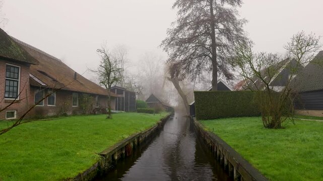 Morning Fog Slips, Mist At Daybreak Cloaks Slender Village Creek As Smoke Rises Softly Above Neat Cottages