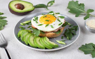 Homemade sandwich with ham, fried egg and avocado for breakfast