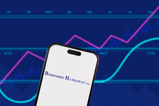 Perrysburgh,Ohio,USA-January 20 2025: Berkshire Hathaway logo on a mobile phone with stock market charts. Concept for diversified holding companies, value investing, and market trends