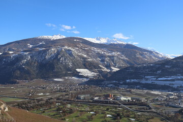 View of the city from above among snow-capped mountains. Magical view.