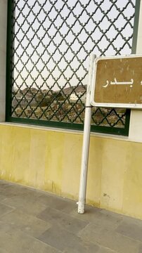 Close-up of the Maqbara Shuhada Badr sign in Madinah, marking the historic cemetery of the martyrs of Badr, an important Islamic heritage landmark visited by pilgrims and history seekers.