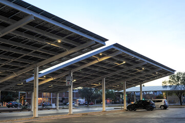 Solar panel carport structures covering a parking lot, representing renewable energy generation, shade infrastructure, and on site power production for commercial facilities