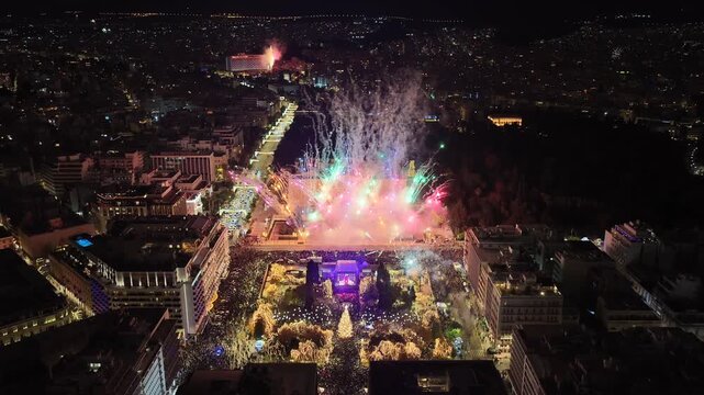 Aerial drone cinematic video of illuminated festive Syntagma square featuring firework show and Christmas tree during New Year's Eve, Athens centre, Attica, Greece