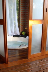 Whirlpool bath in a romantic space surround by a wood deck and nature view