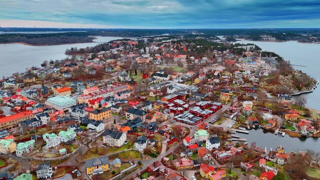 Beautiful colorful cityscape of Vaxholm surrounded by Lake Malar. Low-rise Sweden city scenery from drone on gloomy day.