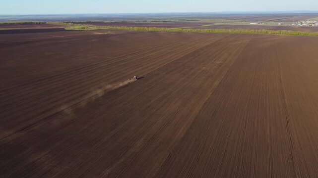 A tractor plowing a field in spring, aerial view