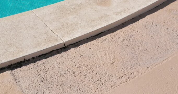 PORTOCOLOM, MALLORCA, SPAIN - OCTOBER, 2025: Ripples move across the surface of a bright swimming pool on a sunny day, shot shows the water near the pool's edge.