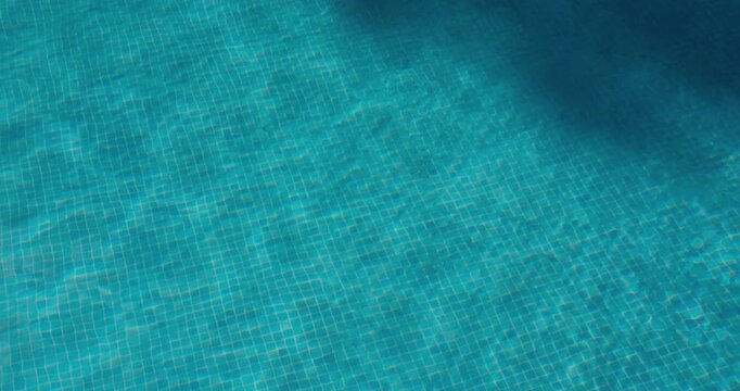 PORTOCOLOM, MALLORCA, SPAIN - OCTOBER, 2025: Turquoise water glistens on a sunny day, pool reflects the sunlight with subtle ripples.
