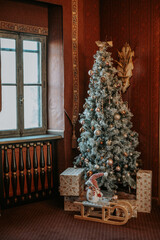 Sapin de Noel d&eacute;cor&eacute; pr&egrave;s d'une fen&ecirc;tre avec lumi&egrave;re douce d'hiver 