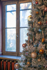 Sapin de Noel d&eacute;cor&eacute; pr&egrave;s d'une fen&ecirc;tre avec lumi&egrave;re douce d'hiver 