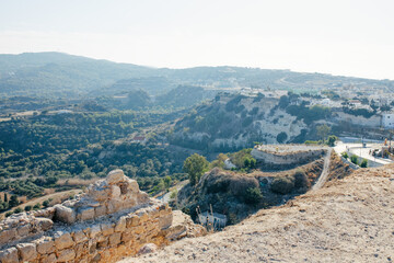 Characteristic features of a Greek island include dry terrain, strong sunlight, blue sea, rocky...