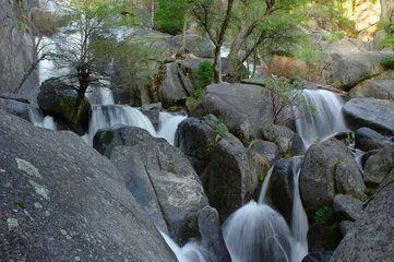 Fototapete Wald Fluss water cascades down and over boulders in Yosemite national park    © lester