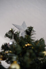 Close-Up of Silver Glitter Star on Top of Christmas Tree