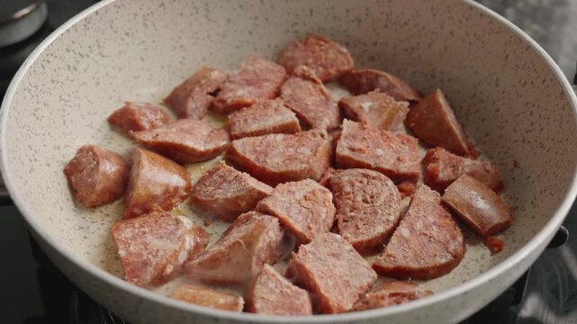 Sliced Traditional Turkish Sucuk Sausage Slowly Frying in a Pan