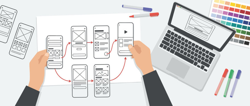 UX designer's hands arranging mobile wireframes into a user flow diagram on a desk with a laptop, color palette, and markers in a flat lay illustration style